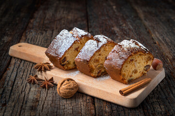 Christmas stollen with dried fruits, cut on a board and a wooden table. For a holiday close-up.