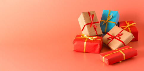 Lots of gifts wrapped in paper and tied with ribbon. Pink background. Banner