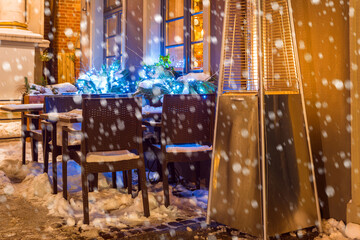 Street cafe with fireplace by night in Gdansk in winter time. Po
