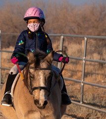Girl on horse with mask