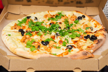 Pizza in a cardboard box for delivery. Pizza in the in delivery box with open lid. Pizza delivery