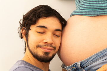 Couple enjoying pregnancy showing their love on a white background