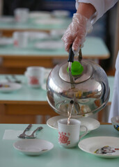 In kindergarten, tea is poured from a kettle with sterile gloves. Measures accordingly covid19.