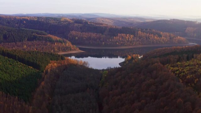 the obernau dam in germany with the rothaar mountains in autumn