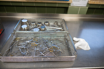 some various surgical instruments lie in sieves on a work surface