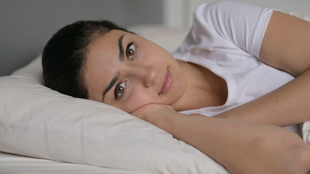 Indian Woman Laying In Bed Looking At Camera