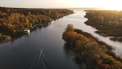 View of the Volga river in autumn from a height with a passing boat