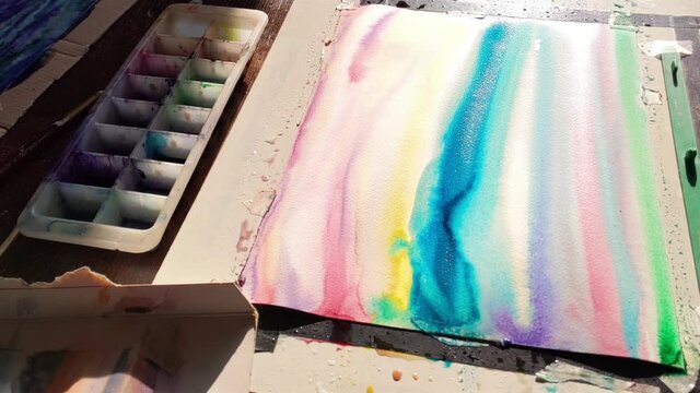 watercolorist at work, making of a colorful artwork