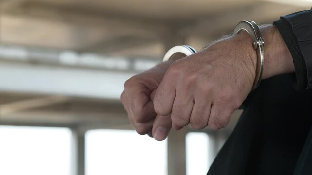 Hands of man in handcuffs close up. 4K 60fps video