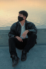 Asian man sit at riverside with black fabric face mask - 403316736