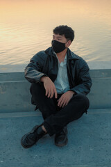 Asian man sit at riverside with black fabric face mask - 403316783