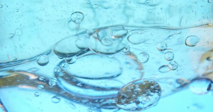 Oil and water mix in slow motion in macro, transparent container for graphics and text background plate