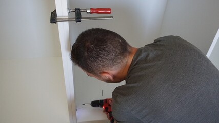 Operario montando armario esquinero blanco a medida