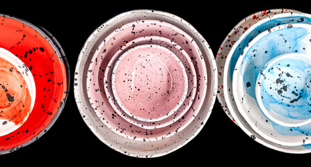 Set of colorful craft ceramic or pottery plates, above view, black isolated