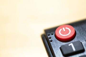 Power button close-up on TV remote control with braille and copy space