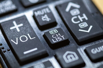 Volume button close-up on TV remote control with braille