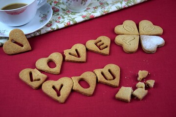 I love you too, inscription with cookies, drunk coffe, lipstic on cup, crumbs, red background, przy walentynkowej kawie