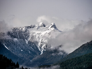 Lions peak mountain in the fog. Clouds and snow from cleveland dam and Capilano Lake