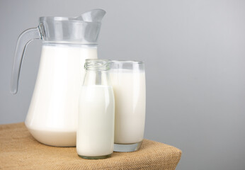 A jug and bottle of fresh milk glass on sackcloth for a background..Raw milk is high in calcium and protein to drink for all ages..Milk consumption nutritious and healthy dairy products concept.