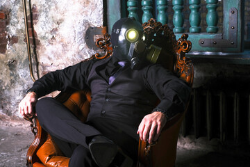 Fototapeta na wymiar cosplay of a guy in a gas mask sitting on a leather chair with glowing eyes