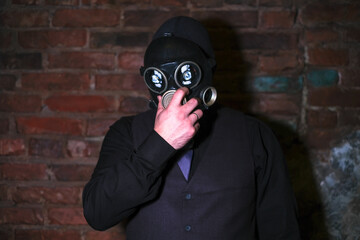 cosplay of a guy in a gas mask on a brick background with glowing eyes