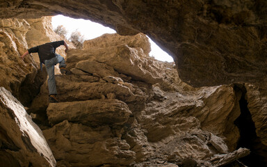 person climbing out of cave