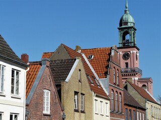 Fototapeta na wymiar Hausfassade mit Turm der Remonstrantenkirche in Friedrichstadt / Nordfriesland