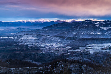 Fototapeta na wymiar Snowy winter mountainous landscape on a cold sunrise. Icy landscape with hoarfrost. Mountain range of Bellmunt, Osona, Catalonia, Spain with Pyrenees at background.