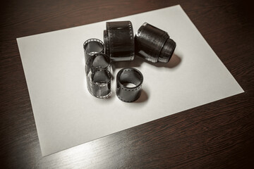 Reels of black and white film on a white sheet of paper, analog film, retro photography
