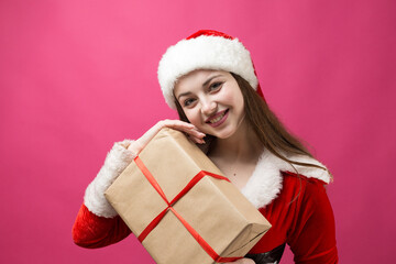 Beautiful young woman in Santa Claus costume against the red background.