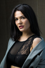 Fototapeta premium Portrait of a young sexy brunette girl in a lace top in dramatic tones. Vintage photo.