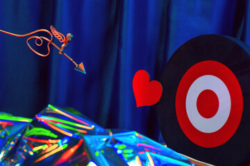 Small golden cupid marks his target with an arrow at the heart, valentine's day concept.