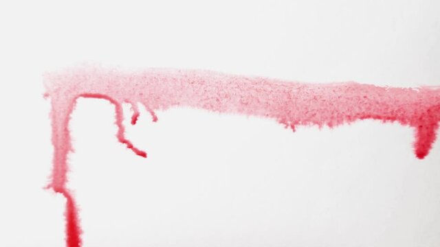 brush strokes of watercolor red paint on a sheet of white paper.