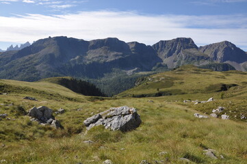 Trawiaste zbocza gór widziane z łąki, Dolomity