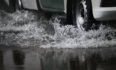 Car run through flood water after hard rain with water spray from the wheels .Stop action ( capture...