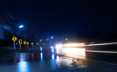 Night scene of wet street after hard rain fall  with blurry cars and light reflections,long-exposure shot.