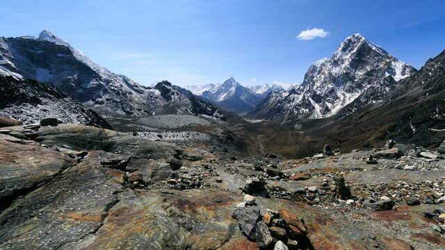 Timelapse view of rocky valley and impressive Himalaya mountains covered with snow. Bright vast sky is above. Way from Lobuche to Dzongla. Nepal
