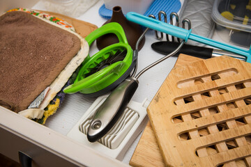 Kitchen drawer filled with potholders, trivets, and kitchen utensils