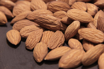 Almonds on dark surface, closeup
