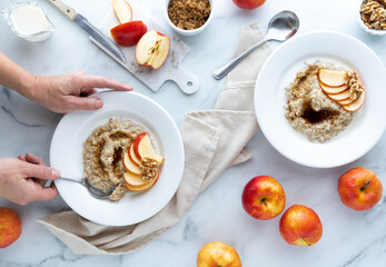 Steel cut oats with brown sugar and apple against a light background.