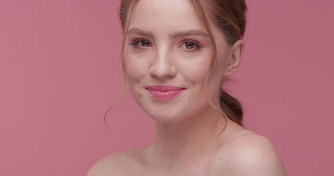 Charmingly Nude Girl is showing Natural Beauty, smiling Softly to the Camera. Red-haired Girl is having healthy Skin with Wrikless and perfect thick Hair. Girl smiling with white Teets on Studio.