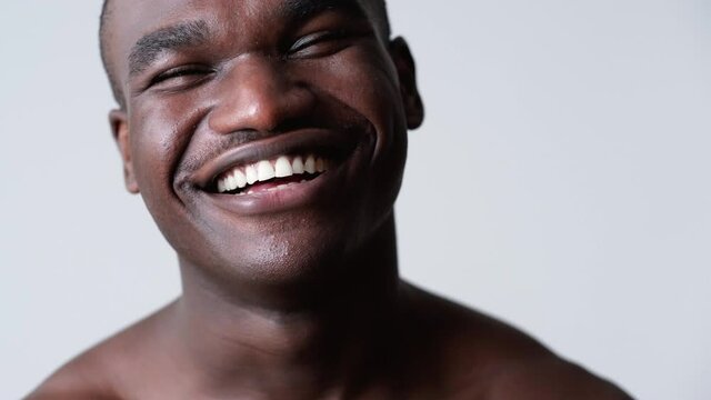 African man portrait. Black lives matter. Confident happy friendly dark skin guy smiling showing white teeth isolated on neutral background.