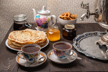 Tea party with samovar, crepes, bagels, honey, jam