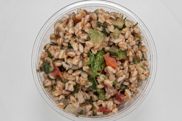 Overhead view of farro grain served by the pound in clear plastic container for presentation of the savory contents
