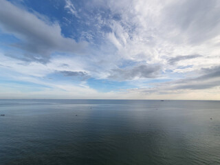 Bue ocean sea water with calm waves and cloudy sky horizon visible in the distance