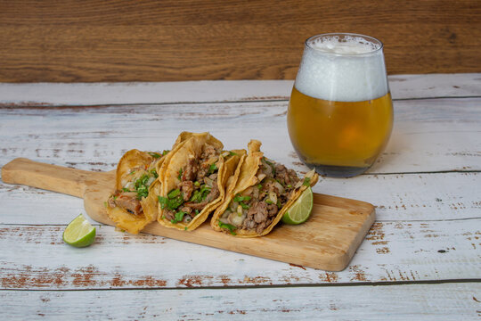 Mexican birria tacos with salsa and cilantro with glass of beer. mexican food