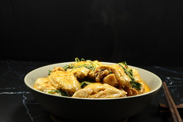 Steamed chicken with red curry and basil serving in the bowl. Famous traditional spicy chicken in Thai style. 