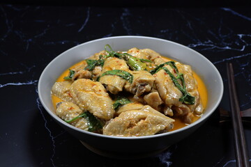 Steamed chicken with red curry and basil serving in the bowl. Famous traditional spicy chicken in Thai style. 