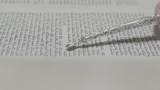 Reading a Torah scroll. 4K Side view Close-up