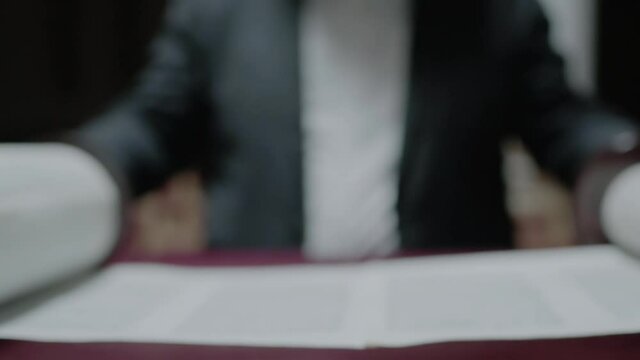 Young Jewish man reading a Torah scroll. Slow motion. Close-up